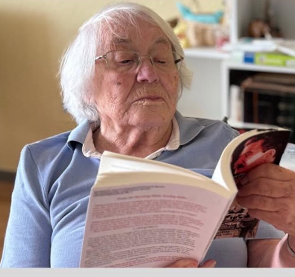 Inge Bursche, 92, reading Surviving Hitler, Evading Stalin at home in Germany